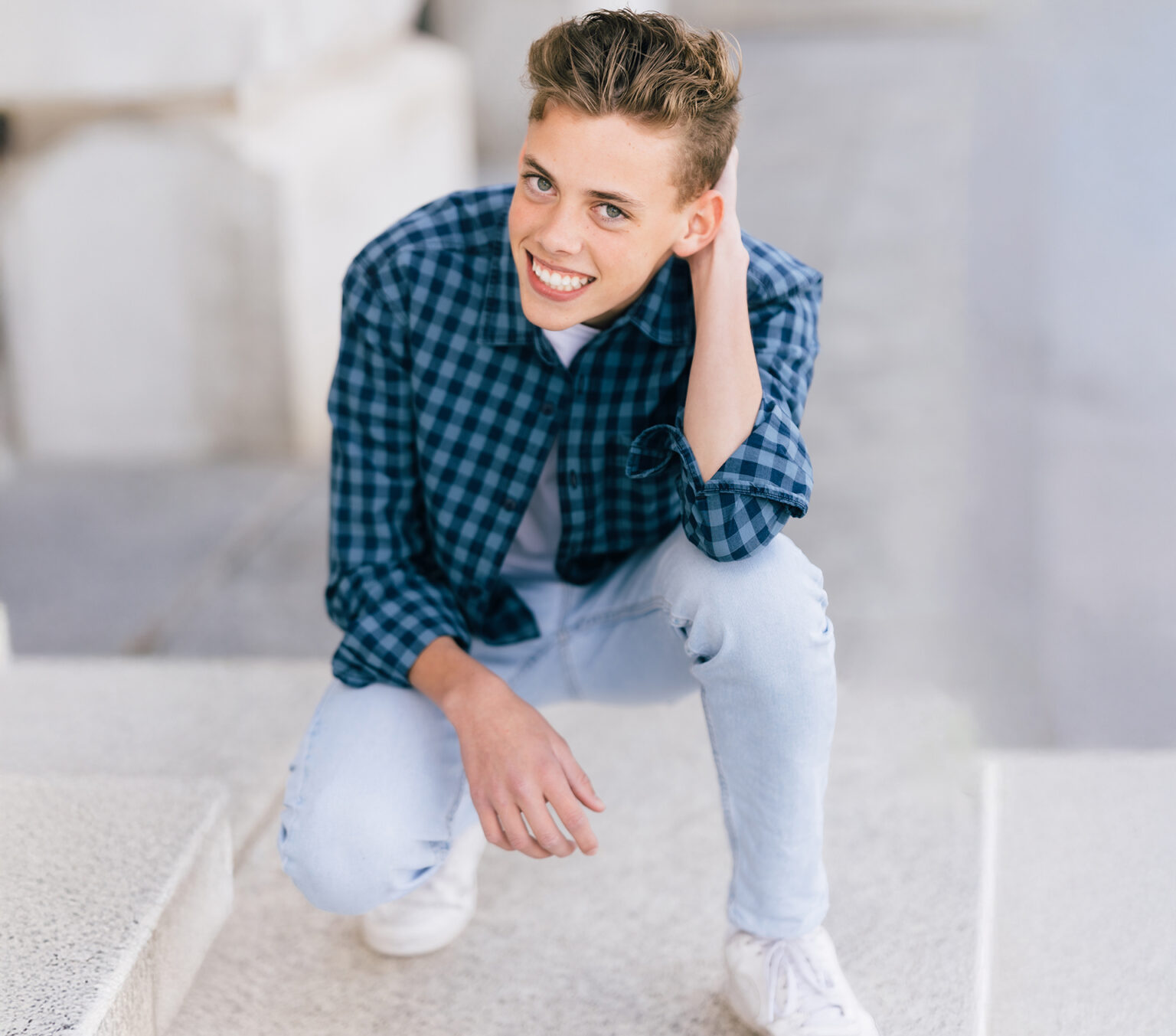 Teen in a blue flannel smiling after leaving a glowing review for Bountiful Orthodontics